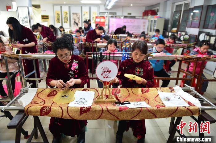 江西省級(jí)非遺豫章繡傳承人手把手指導(dǎo)小學(xué)生繡制2022年北京冬奧會(huì)吉祥物“冰墩墩”形象?！∮髟屏?攝