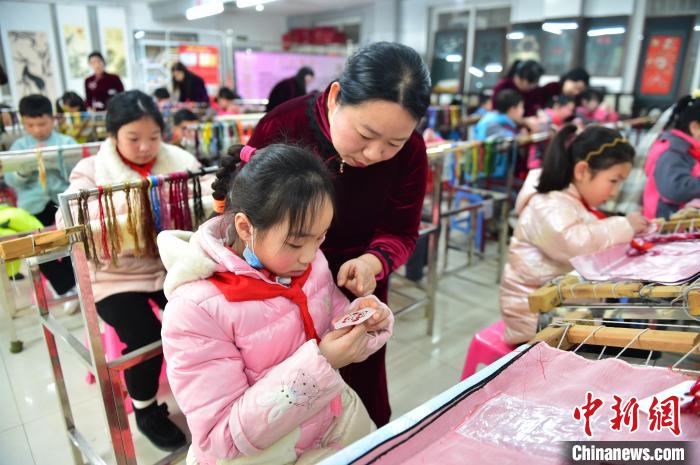 江西省級(jí)非遺豫章繡傳承人手把手指導(dǎo)小學(xué)生繡制2022年北京冬奧會(huì)吉祥物“冰墩墩”形象?！∮髟屏?攝