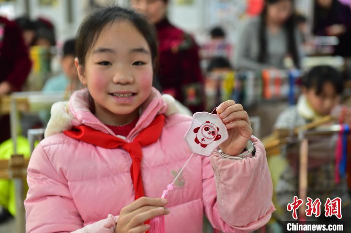 圖為一名小學(xué)生繡制的2022年北京冬奧會(huì)吉祥物“冰墩墩”形象?！∮髟屏?攝