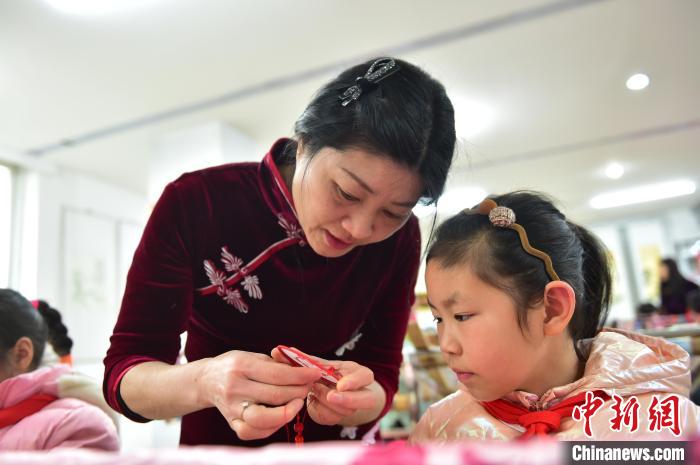 江西省級(jí)非遺豫章繡傳承人手把手指導(dǎo)小學(xué)生繡制2022年北京冬奧會(huì)吉祥物“冰墩墩”形象?！∮髟屏?攝