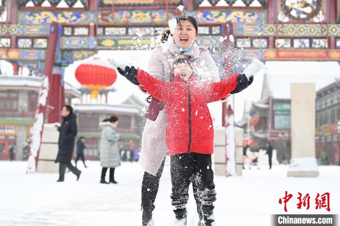 2月13日，家長與小朋友在呼和浩特市大召廣場享雪趣?！⑽娜A 攝
