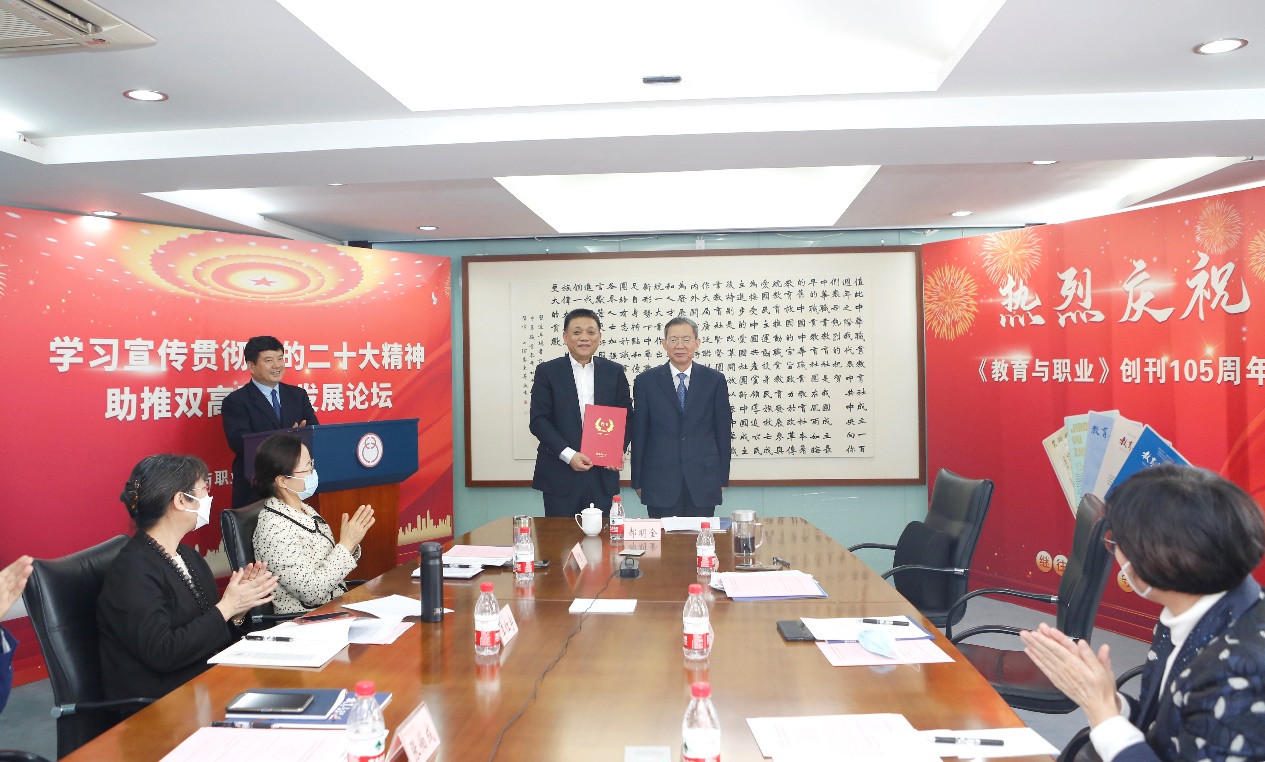 郝明金為《教育與職業(yè)》雜志編委代表陳曉明頒發(fā)聘書。中華職教社供圖