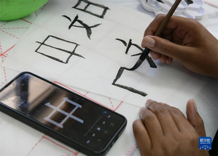 4月18日，肯尼亞學(xué)生在內(nèi)羅畢大學(xué)孔子學(xué)院舉辦的活動(dòng)上寫毛筆字?？夏醽唭?nèi)羅畢大學(xué)孔子學(xué)院18日舉辦“中文，增進(jìn)文明對(duì)話”主題活動(dòng)，慶祝即將到來的第14個(gè)聯(lián)合國(guó)中文日?？夏醽唽W(xué)生參與互動(dòng)，進(jìn)行書法、剪紙、唱中文歌等活動(dòng)。新華社記者 韓旭 攝