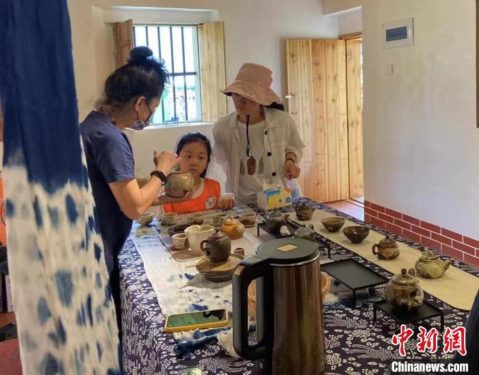 圖為：游客正在咨詢臺灣柴燒作品?！∪~秋云 攝