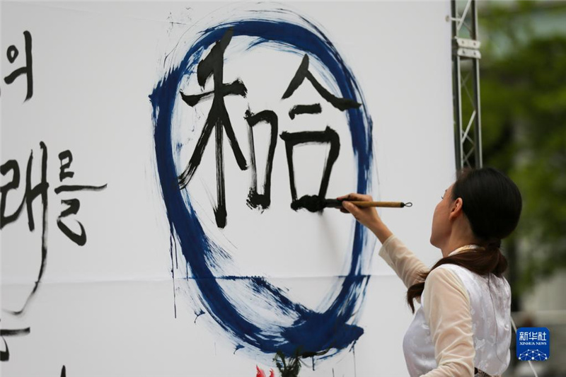 5月30日，在韓國首爾舉辦的“中日韓合作之日”慶祝活動中，表演者進行中日韓精神——2023年度漢字“和合”書法表演。新華社記者 王益亮 攝