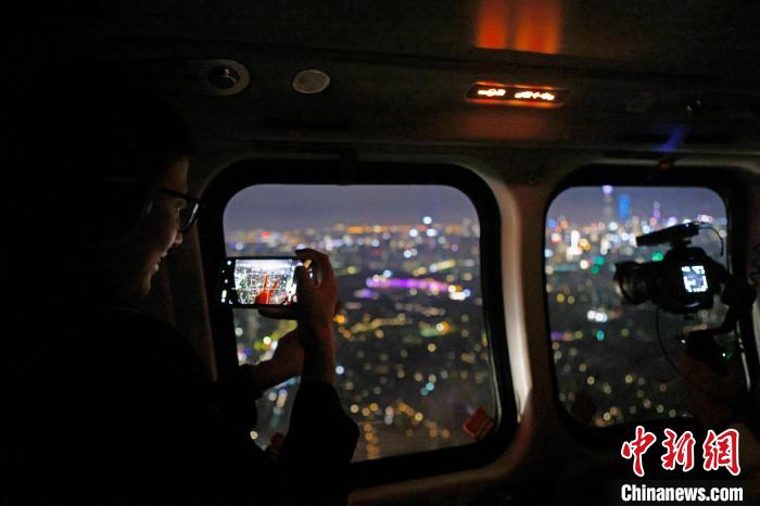 6月3日晚，游客乘坐上海新空直升機(jī)有限公司直升機(jī)開啟鳥瞰黃浦江空中圓夢之旅，并用手機(jī)拍攝城市夜景?！∫罅⑶?攝