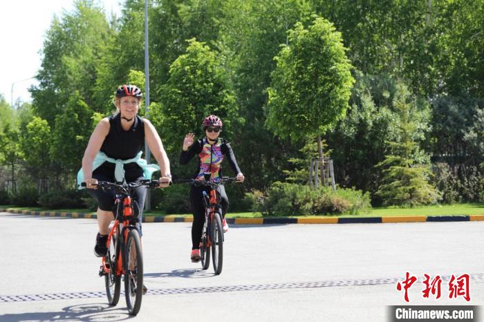 亞信副秘書長(zhǎng)遲方(右一)與聯(lián)合國(guó)駐哈協(xié)調(diào)員在騎行活動(dòng)中?！喰琶貢幑﹫D