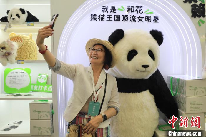 美國華視總裁楊蓮花與大熊貓文創(chuàng)產(chǎn)品合影。　王磊 攝