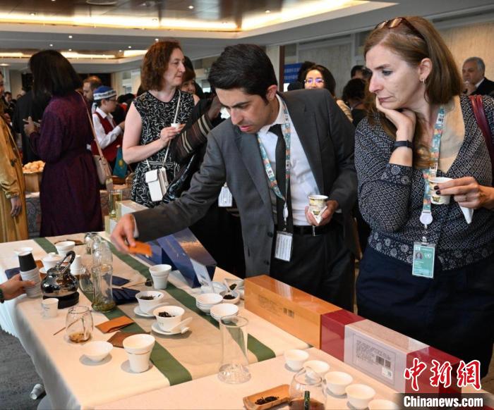 現(xiàn)場觀眾觀看中國展臺茶藝表演、了解茶文化。　靖樹 攝