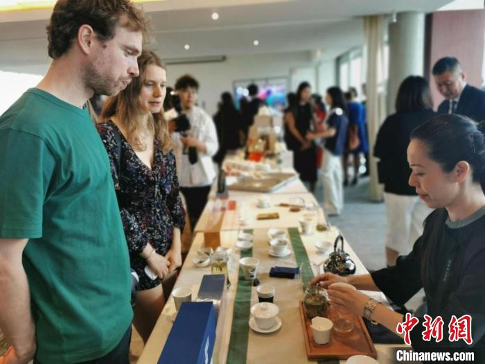 現(xiàn)場觀眾觀看中國展臺茶藝表演、了解茶文化。　靖樹 攝