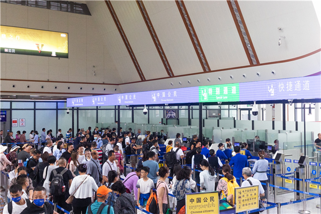 7月22日，乘坐中老鐵路國際旅客列車的旅客在磨憨邊檢大廳排隊(duì)候檢。衛(wèi)海林 攝