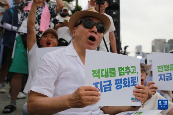 7月22日，在韓國首爾，人們手舉標語參與反戰(zhàn)游行。新華社發(fā)（楊暢 攝）