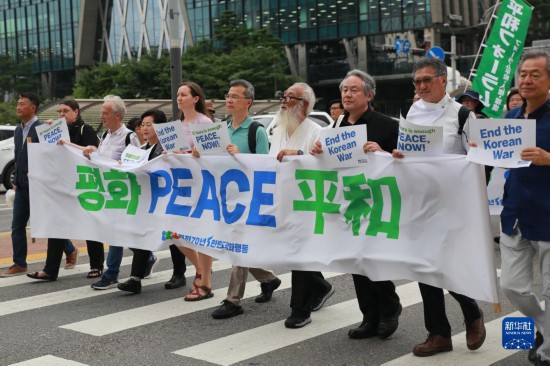 7月22日，在韓國首爾，人們手舉標語參與反戰(zhàn)游行。新華社發(fā)（楊暢 攝）