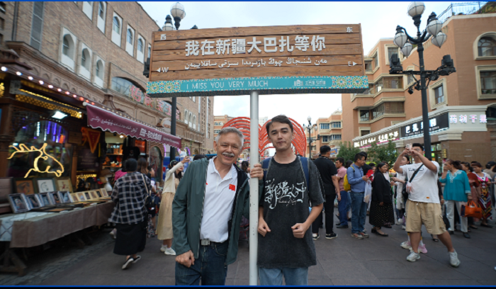 潘維廉和維吾爾族青年伊木蘭“打卡”大巴扎。主辦方供圖