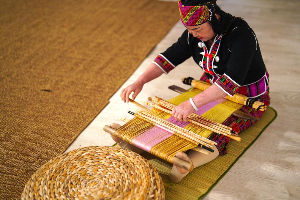 4月17日，黎族傳統(tǒng)紡染織繡技藝國家級代表性傳承人劉香蘭在2023年意大利米蘭設(shè)計周上展示黎錦織造技藝。新華社發(fā)