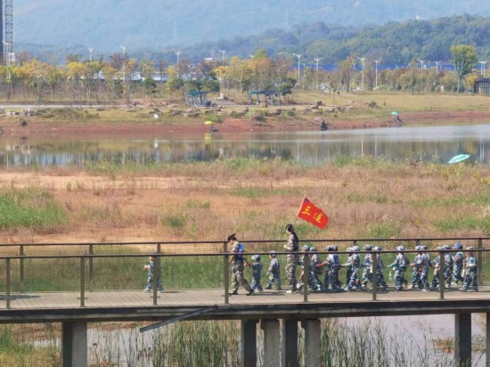 　　10月24日，秋游的幼兒園小朋友在老師帶領(lǐng)下走在清水塘公園里的木橋上。本報記者 常雯宜攝