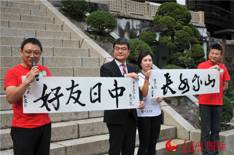 東京中國文化中心主任羅玉泉展示其為本次活動書寫的題詞“中日友好，山高水長”。人民網(wǎng) 蔣曉辰攝