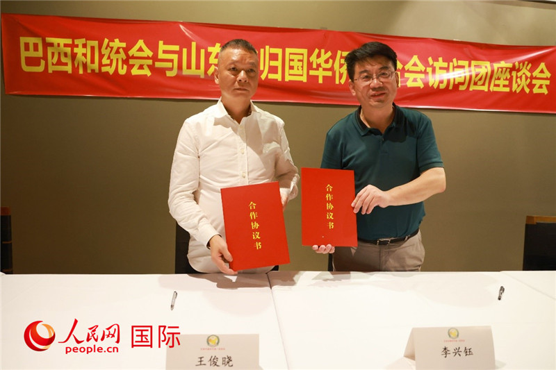 中國僑聯(lián)副主席、山東省僑聯(lián)主席李興鈺（右）與巴西和統(tǒng)會會長王俊曉簽署合作協(xié)議書。人民網(wǎng)記者 陳海琪攝
