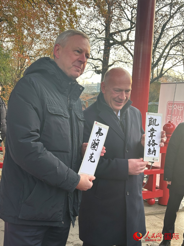柏林市長(zhǎng)韋格納（右）、動(dòng)物園監(jiān)事會(huì)主席布魯克曼（左）手持中國(guó)文化中心工作人員現(xiàn)場(chǎng)手書的中文名字。人民網(wǎng)記者 徐馨攝