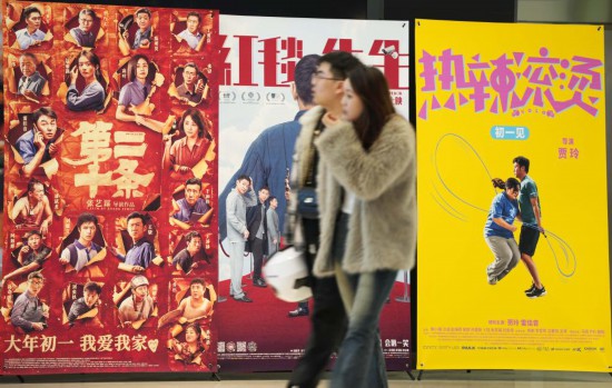 這是2月17日，在沈陽(yáng)一家影院，觀眾從海報(bào)前經(jīng)過(guò)。新華社記者李鋼攝