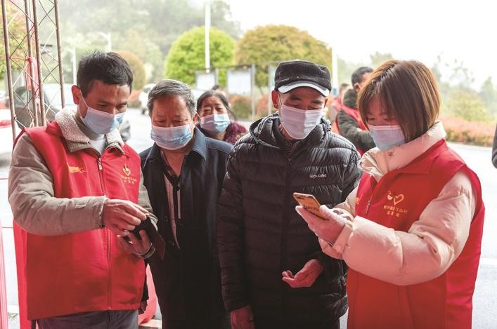 長沙縣黨員志愿者正在幫助參與核酸檢測的群眾掃描“場所碼”。劉思源 攝