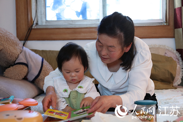 王繼蓮帶孫女看童書。人民網(wǎng) 冷金明攝