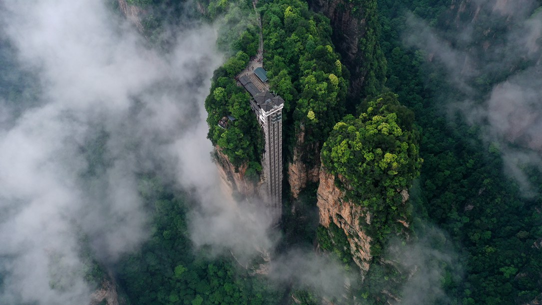 位于張家界武陵源景區(qū)的百龍?zhí)焯蓁偳对谠旗F繚繞的峰林間，雄偉壯觀。吳勇兵攝