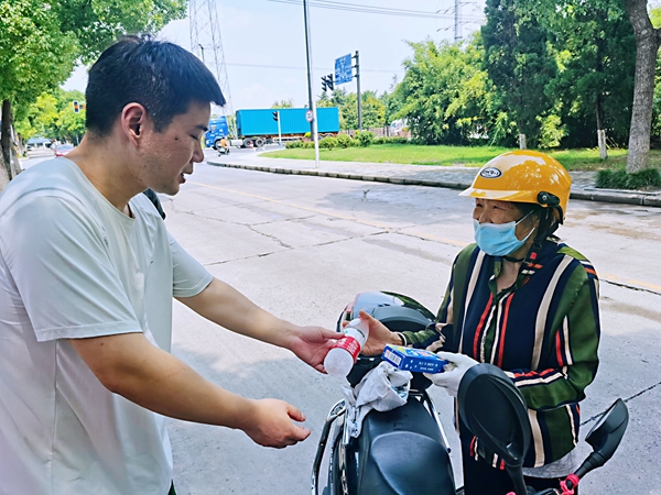 何超為過路的老人送上礦泉水和冷飲。人民網(wǎng)記者 王繼亮攝
