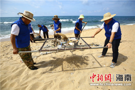 環(huán)保志愿者用篩網(wǎng)“淘”出海灘上的垃圾。