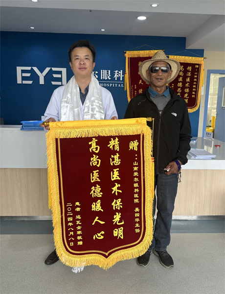 達(dá)瓦老人向吳四華（左）贈(zèng)送錦旗。受訪者供圖