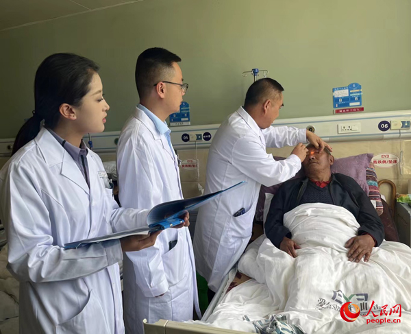 董光明（左三）帶領(lǐng)醫(yī)生對(duì)患者進(jìn)行術(shù)前檢查。人民網(wǎng)記者 杜燕飛攝