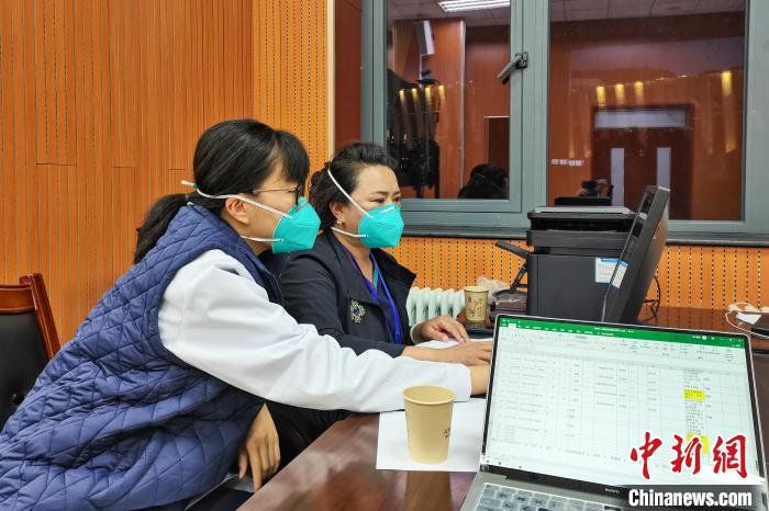 8月9日，楊蘇喬(左)在拉薩方艙醫(yī)院指揮部讀取艙內(nèi)患者胸部CT?！∈茉L者供圖