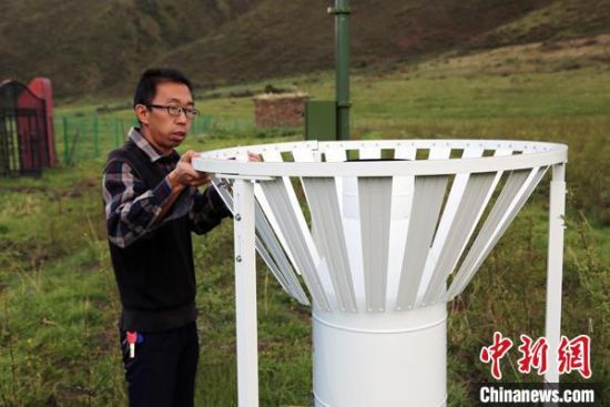 圖為班瑪縣氣象局工作人員在維護藏雪茶基地氣候站。青海省氣象局供圖