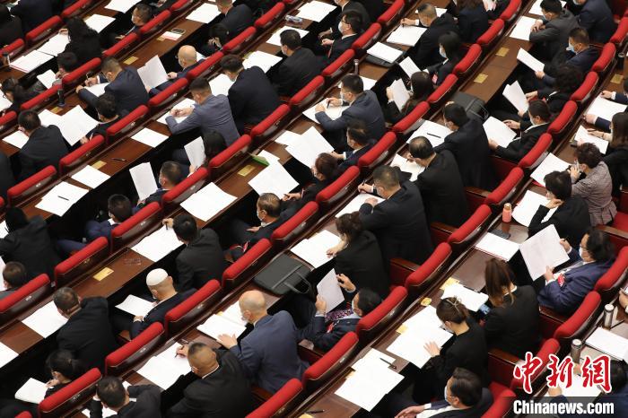 圖為會議現(xiàn)場，參會代表正在聽取政府工作報告?！∑钤鲚?攝
