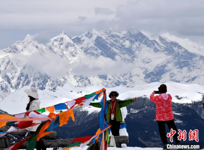 圖為5月14日，西藏林芝色季拉山觀景臺(tái)，游客與南迦巴瓦峰合影?！±盍?攝
