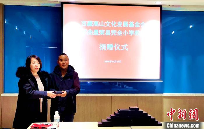 圖為西藏高山文化發(fā)展基金會理事長溫麗向聶榮縣完全小學(xué)負(fù)責(zé)人捐助儀器?！∮谫e 攝