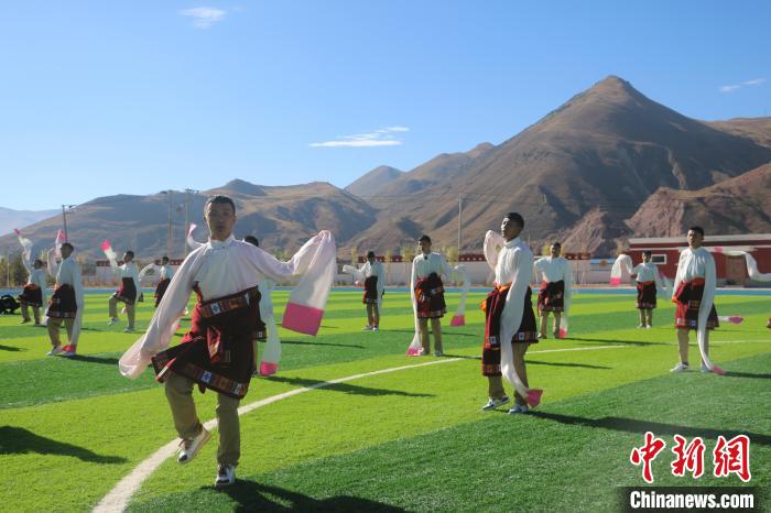 圖為青海師范大學(xué)附屬玉樹實驗學(xué)校學(xué)生在綠茵場跳起囊謙古舞—卓根瑪?！〕逃?攝