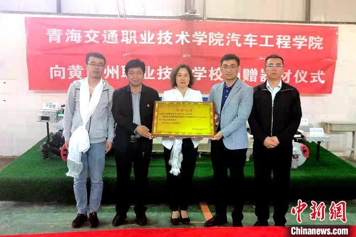圖為李富香(中)代表學(xué)校為州縣技校捐贈(zèng)器材。(資料圖) 青海省教育廳供圖