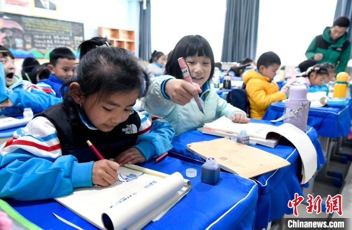 3月14日，西藏拉薩市第一小學(xué)一年級六班學(xué)生白瑪朗珍(圖左)在藏語文課上書寫藏文?！±盍?攝