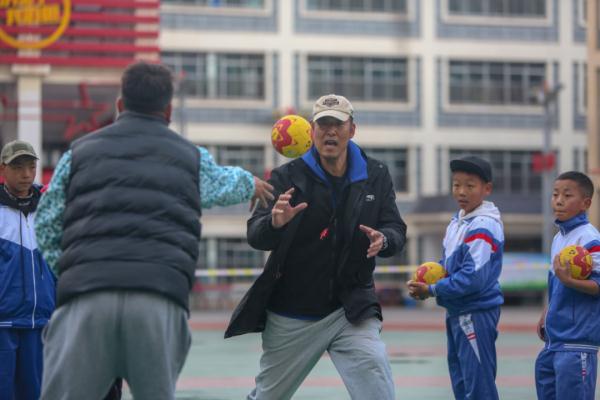 在高原上教孩子們打手球，“慢慢兒來，甭著急！”
