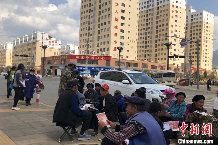 圖為會(huì)澤縣城易地扶貧搬遷安置點(diǎn)內(nèi)，老人們聚在廣場上聊天，身后是他們的新家?！】姵?攝