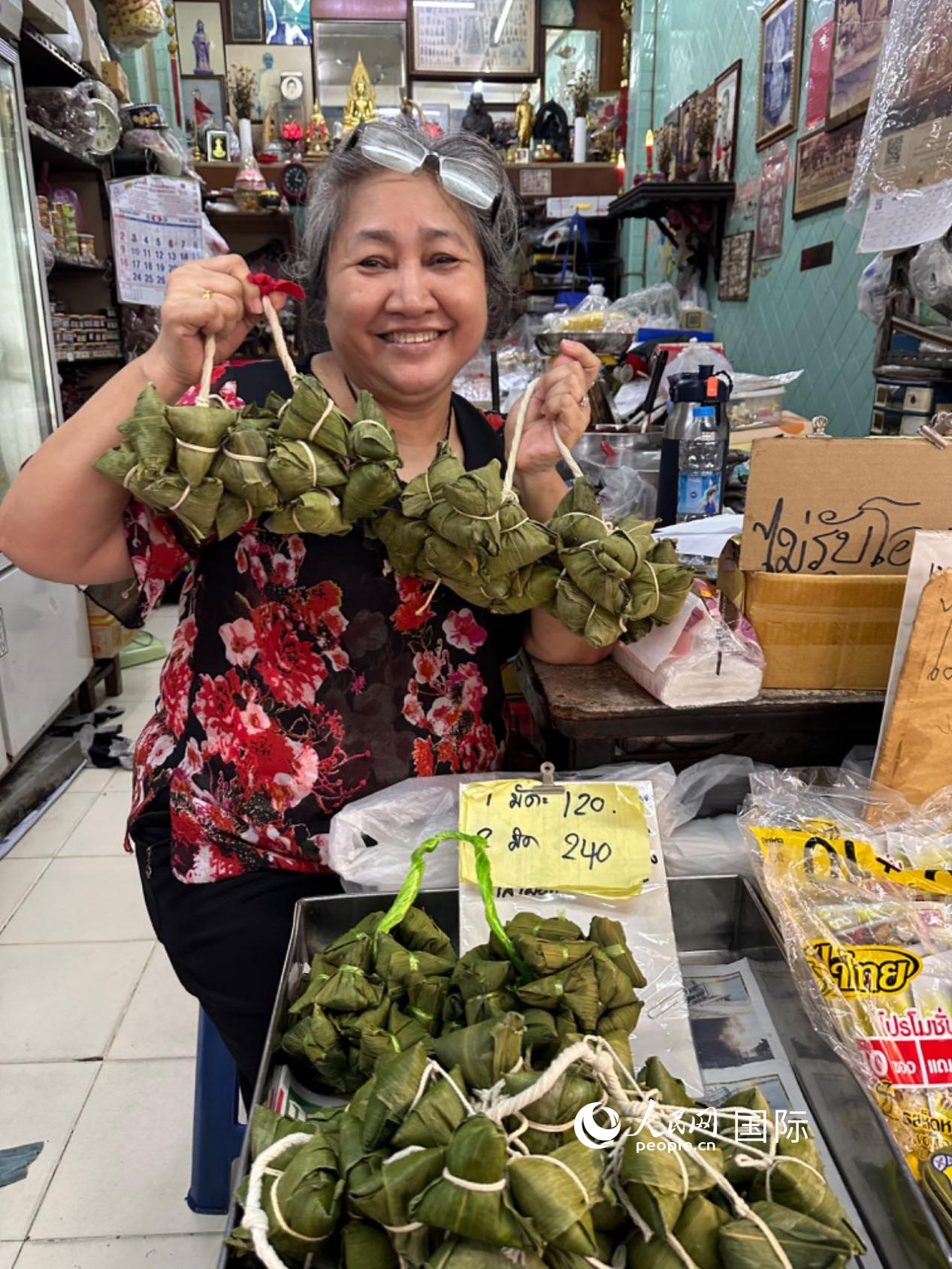 商家向顧客介紹“吉掌”（粽子的一種，一串一串，個(gè)頭較?。?。人民網(wǎng)記者 簡(jiǎn)承淵攝