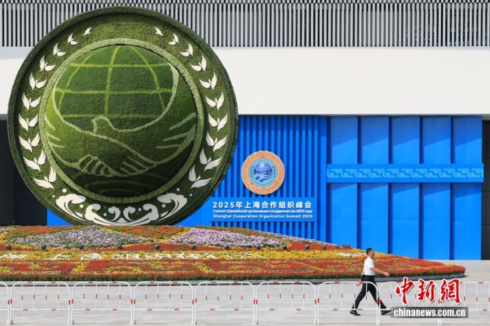 8月31日，天津，一名工作人員從2025年上海合作組織峰會(huì)主會(huì)場(chǎng)外的景觀花壇旁經(jīng)過(guò)。當(dāng)日，2025年上海合作組織峰會(huì)在天津舉行。<a target='_blank' href='/'><p  align=