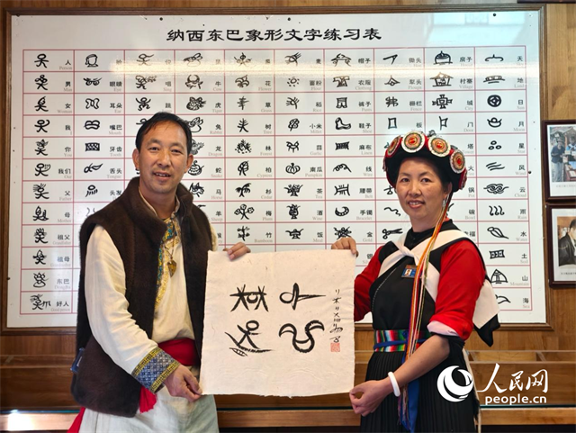 人民網(wǎng)“行進(jìn)中國”云南調(diào)研采訪團(tuán)走進(jìn)麗江，和閏元現(xiàn)場用東巴文寫下“行進(jìn)中國”。人民網(wǎng)記者 符皓攝