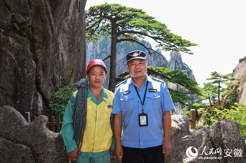 全國道德模范李培生（左）和胡曉春在迎客松前合影。人民網(wǎng)記者 張俊攝