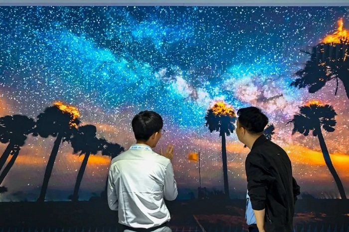長春光博會希達電子展區(qū)，一位工作人員正在給一位觀眾講解。（長春新區(qū)供圖）