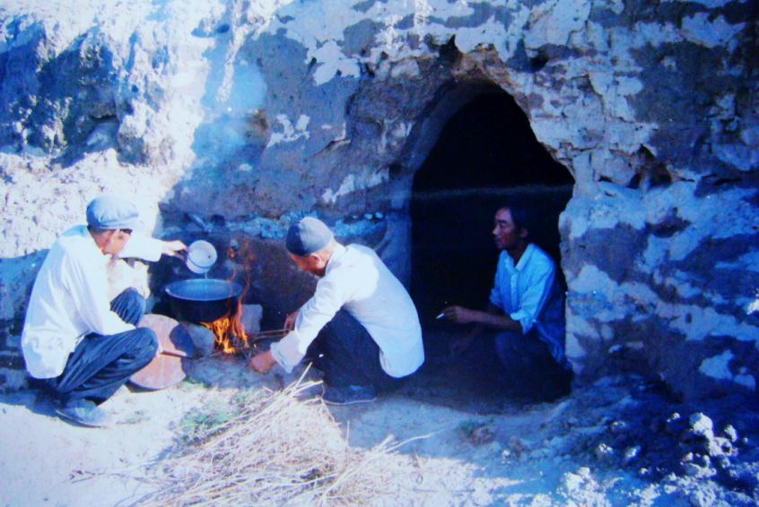 1983年，“六老漢”一代治沙人在“地窩子”生活做飯。新華社發(fā)（八步沙林場供圖）