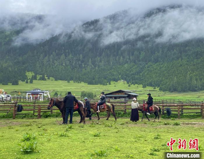 6月10日，游客在魯朗小鎮(zhèn)高山牧場景區(qū)體驗騎馬?！∪轿木?攝
