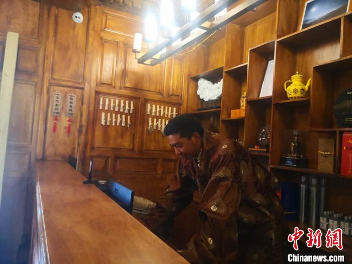 圖為桑杰才讓用電腦處理財務(wù)?！∈缝o靜 攝