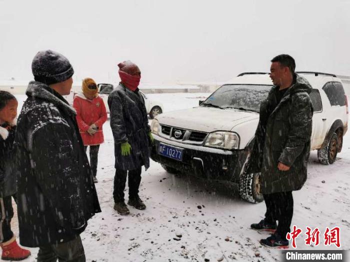 圖為扎西鬧吾(右一)與當(dāng)?shù)啬翍?hù)交談。郵儲(chǔ)銀行青海省分行供圖